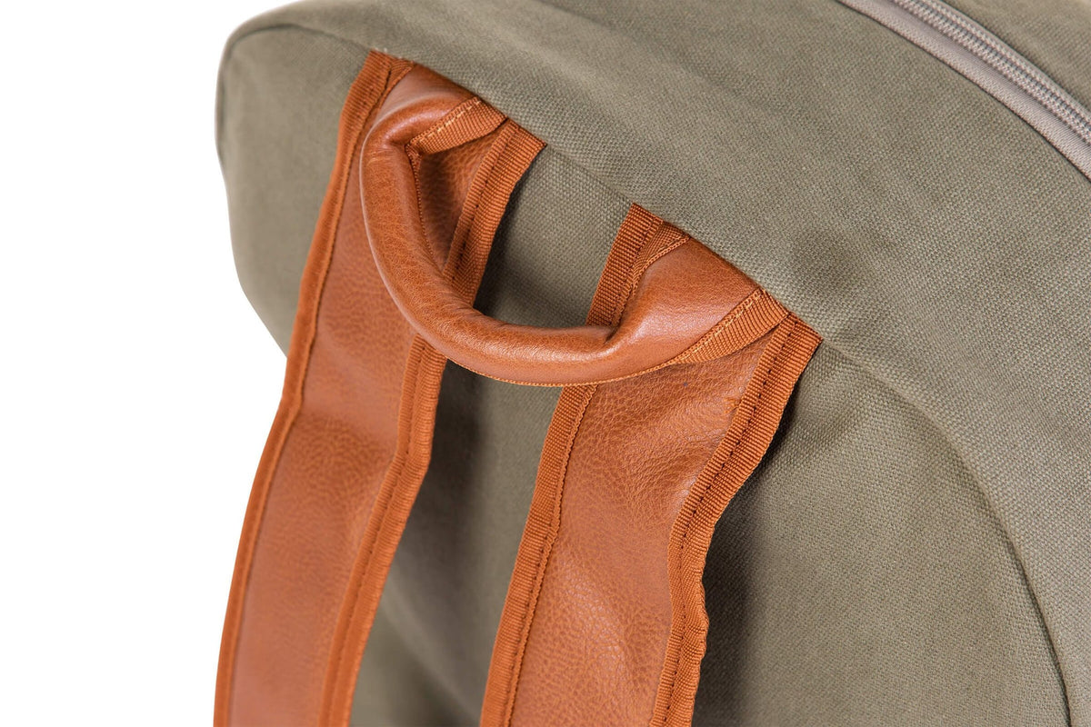 Detail van het bruine handvat en de schouderbanden van de kaki Daddy Bag verzorgingsrugzak.