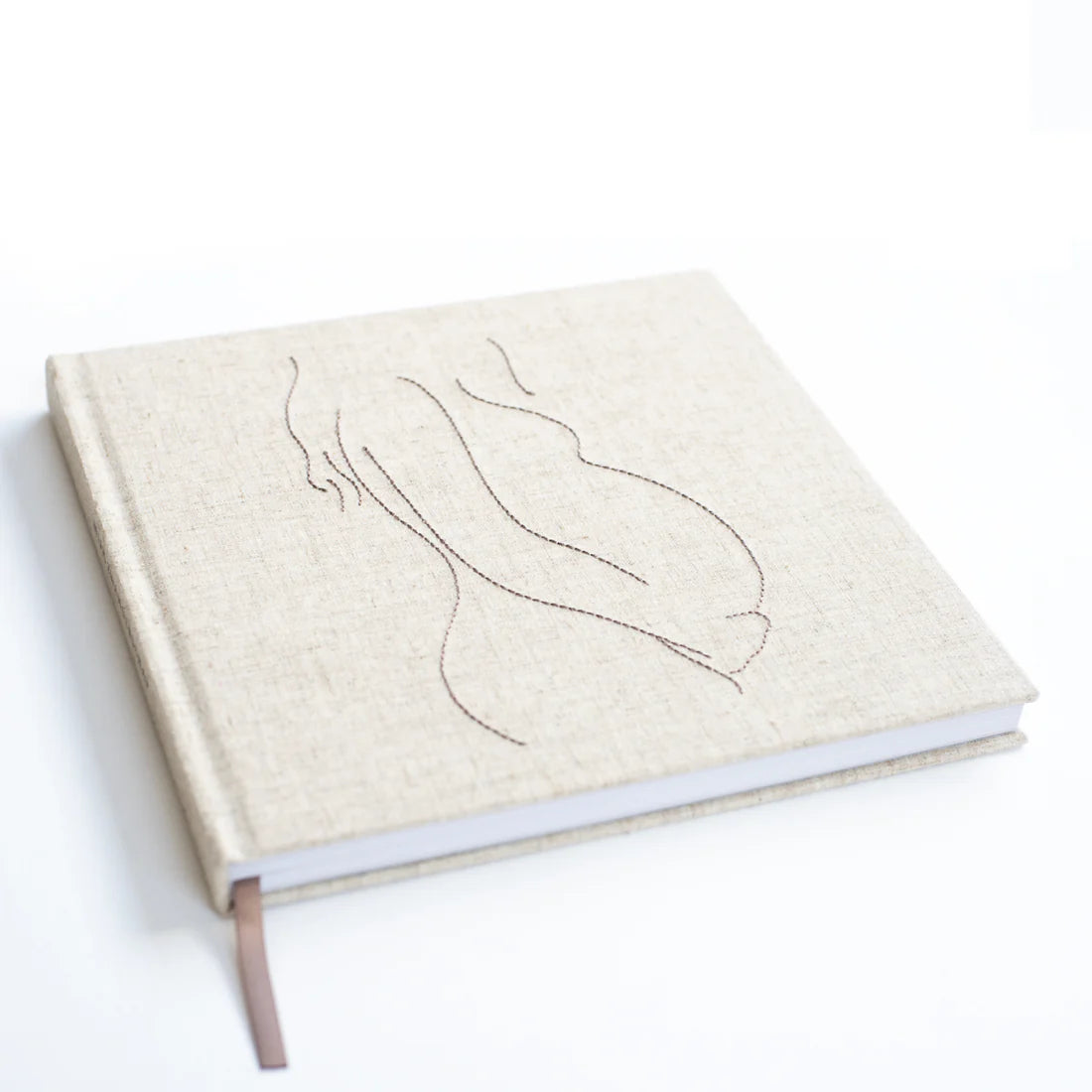 Invulboek Mijn Zwangerschap schuin gezien, met lichtbeige cover, gestikte zwangere buik en bruin leeslint