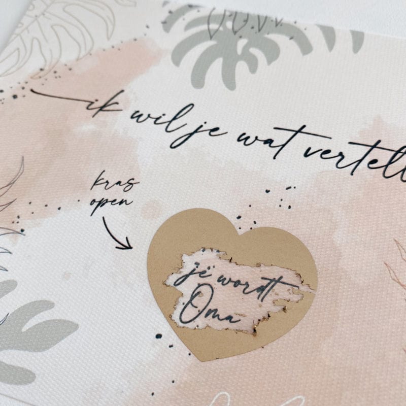 Detail van het opengekraste gouden hartje op de kraskaart, met de onthulde boodschap 'je wordt oma'.