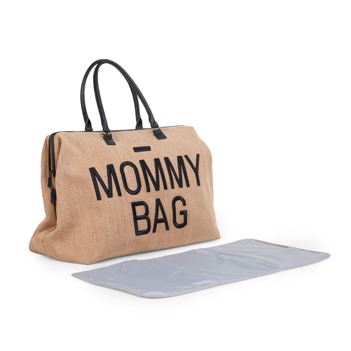 Mommy Bag verzorgingstas met raffialook en zwarte handvatten, met een uitgevouwen grijs verzorgingsmatje ervoor.