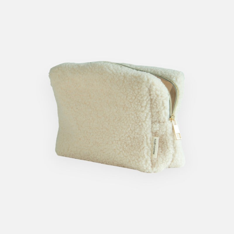 Crèmekleurige Teddy toilettas schuin van achteren, met gedeeltelijk geopende goudkleurige rits.