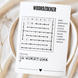 A6 woordzoekerkaart met doorgestreepte woorden en de oplossing 'Je wordt oma', op een bord met lichte stof eromheen.