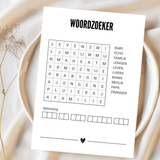 Witte A6-kaart met oningevulde woordzoeker en zwart hartje op een bord met lichte stof en droogbloemen.
