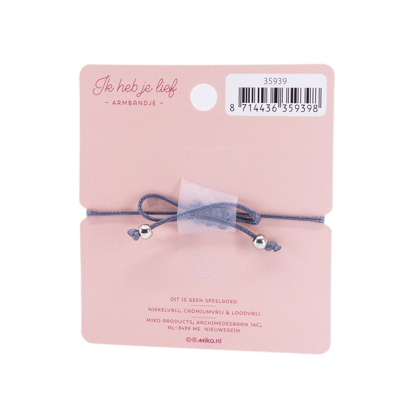 Achterkant van de roze kaart met het grijze armbandje, verstelbare knoop en zilverkleurige kraaltjes.