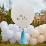 Crèmekleurige ballon met tekst 'Big brother' en blauwe kwastjes, buiten voor een slinger van ballonnen.
