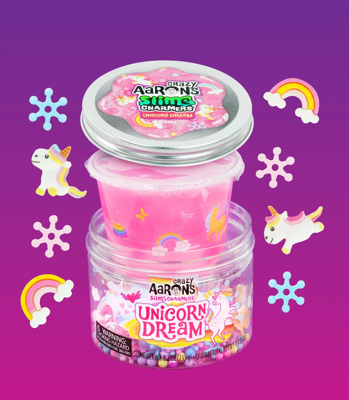 Unicorn Dream-slijm in een bakje boven de open pot, omringd door eenhoorn- en regenboogbedeltjes.