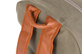 Detail van het bruine handvat en de schouderbanden van de kaki Daddy Bag verzorgingsrugzak.