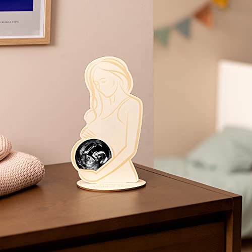 Houten fotolijst Echo met echofoto in de buik van een zwangere vrouw, op een voetje op een houten kast.