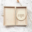 Open houten kistje met een ronde houten schijf met de tekst ‘Wij krijgen een broertje!’ en een hartje.