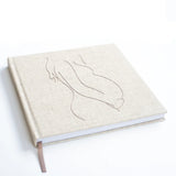 Invulboek Mijn Zwangerschap schuin gezien, met lichtbeige cover, gestikte zwangere buik en bruin leeslint
