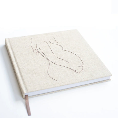 Invulboek Mijn Zwangerschap schuin gezien, met lichtbeige cover, gestikte zwangere buik en bruin leeslint
