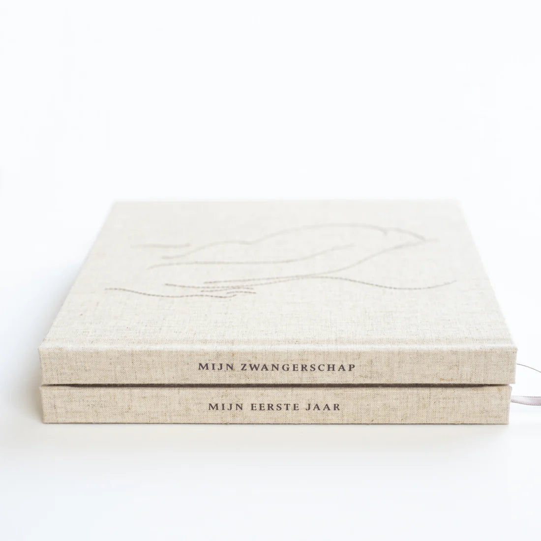 Twee lichtbeige invulboeken op elkaar met de rugtitels Mijn Zwangerschap en Mijn Eerste Jaar