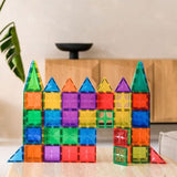 Kasteel van kleurrijke, doorzichtige magnetische bouwblokken met puntdaken en een poort op tafel