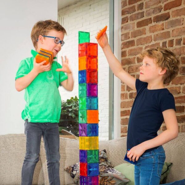 Twee kinderen bouwen een hoge toren met kleurrijke magnetische bouwblokken van Coblo.