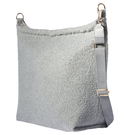 Grijze Mom Bag Teddy Bouclé met verstelbare schouderriem en goudkleurige gespen, van achteren gezien.