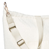 Detail van de verstelbare schouderriem en karabijnhaak aan de ivoorkleurige Mom Bag Teddy Bouclé.