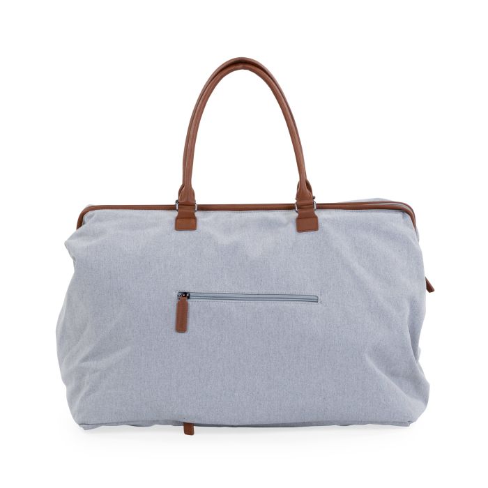 Achterkant van de grijze Mommy Bag verzorgingstas met ritsvak en bruine handvatten.