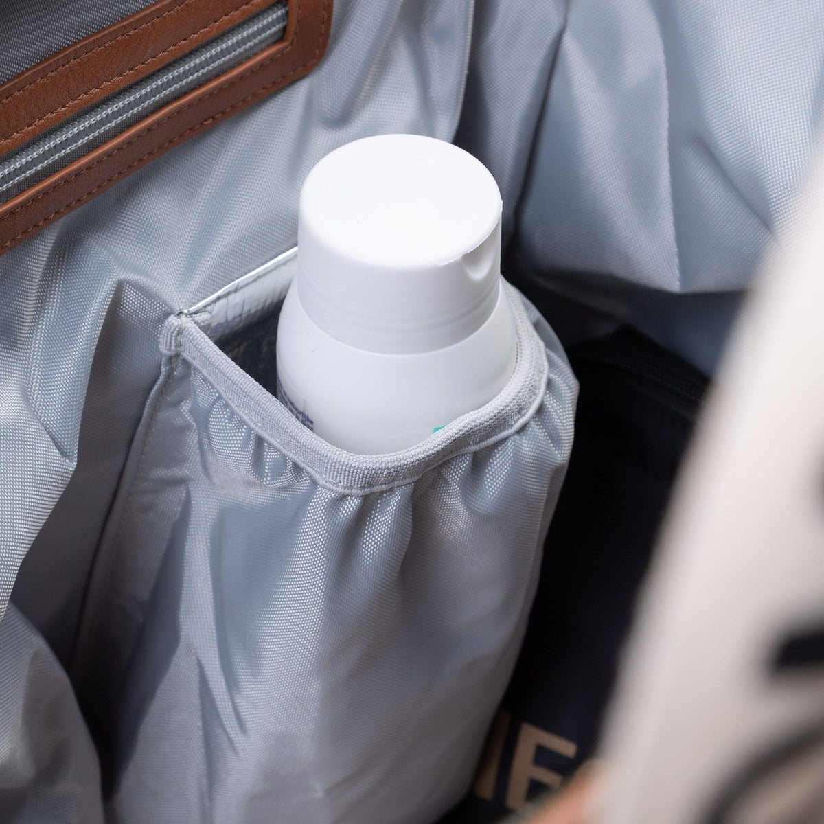 Detail van het grijze koelvakje met een witte fles aan de binnenzijde van de Mommy Bag verzorgingstas.