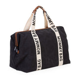 Zwarte Mommy Bag Signature verzorgingstas schuin van voren, met crèmekleurige draagriemen en dubbele ritssluiting.