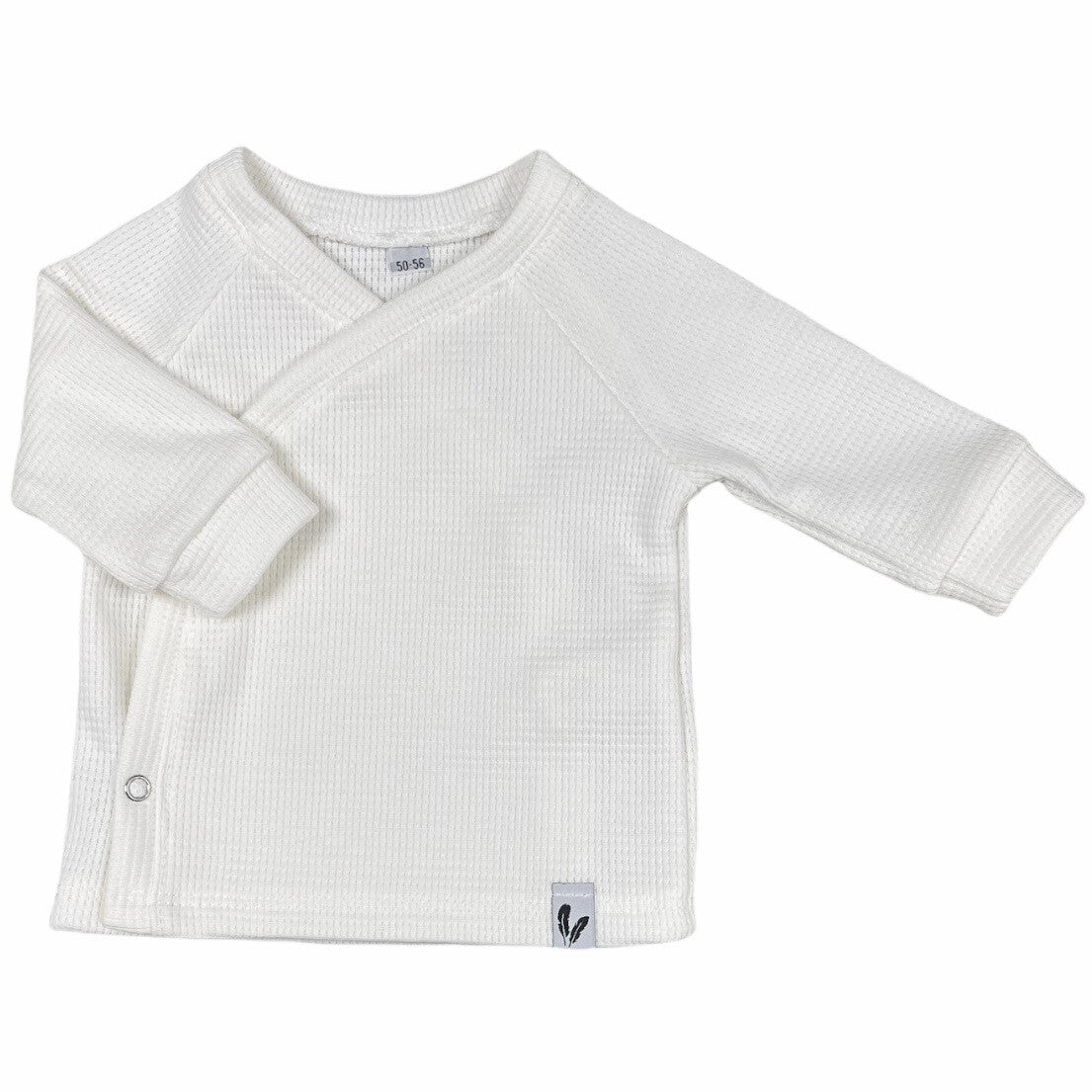 Offwhite baby-overslagshirtje met wafelstructuur, lange mouwen en een drukknoop aan de zijkant.