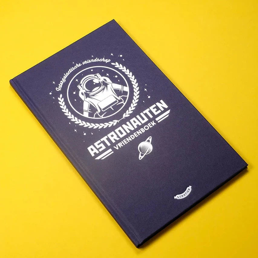 Donkerblauw astronautenvriendenboek met witte astronaut en planeet op de kaft, op een gele achtergrond.