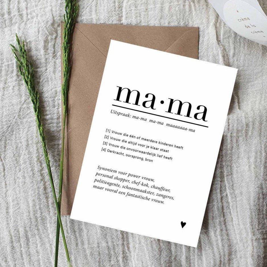 Witte A6-ansichtkaart met zwarte tekst over mama en een hartje, op een bruine envelop naast groene takjes.