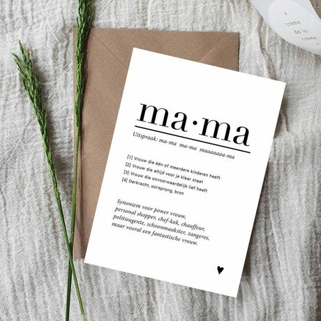Witte A6-ansichtkaart met zwarte tekst over mama en een hartje, op een bruine envelop naast groene takjes.
