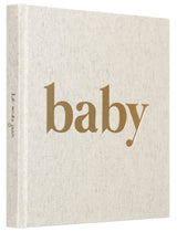 Linnen baby-invulboek schuin van voren, met naturelkleurige kaft, goudkleurige titel en zichtbare rug.
