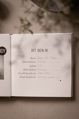 Open babyboek met ingevulde pagina Dit ben ik, met naam, geboortegegevens, gewicht en lengte.