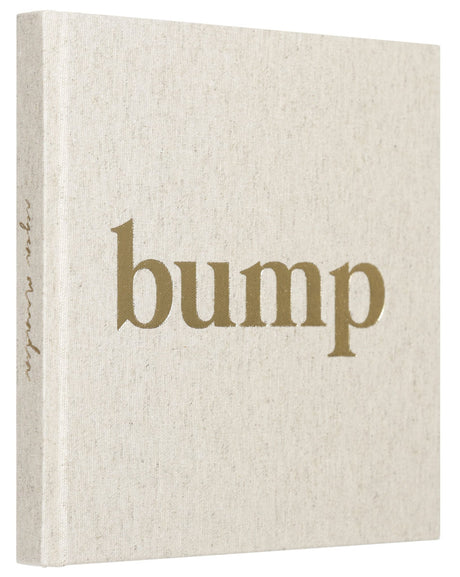 Bump zwangerschapsinvulboek schuin van voren, met naturelkleurige linnen kaft en goudkleurige opdruk.
