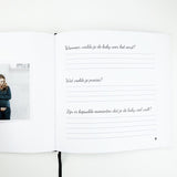Open zwangerschapsdagboek met vragen over de eerste babybewegingen, een zwangerschapsfoto en zwart leeslint.