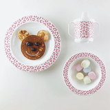 Servies Leopard Blush met een pannenkoekengezicht op het bord, marshmallows in de kom en een tuitbeker ernaast.